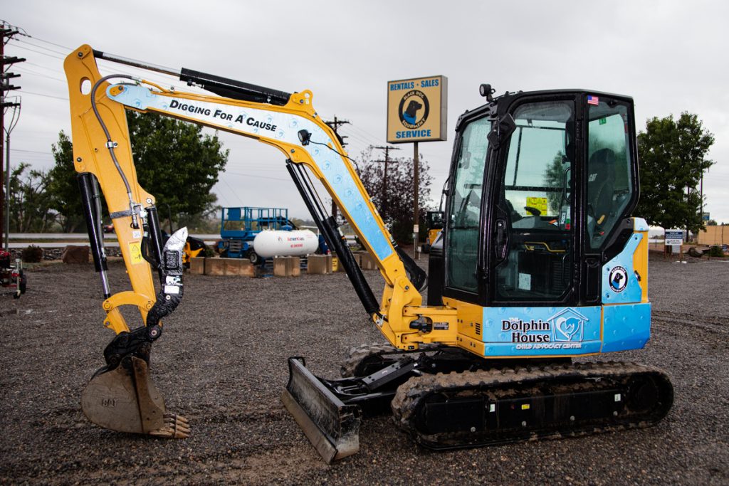 Side profile Caterpillar 304 Mini Excavator for Rent with The Dolphin House logo
