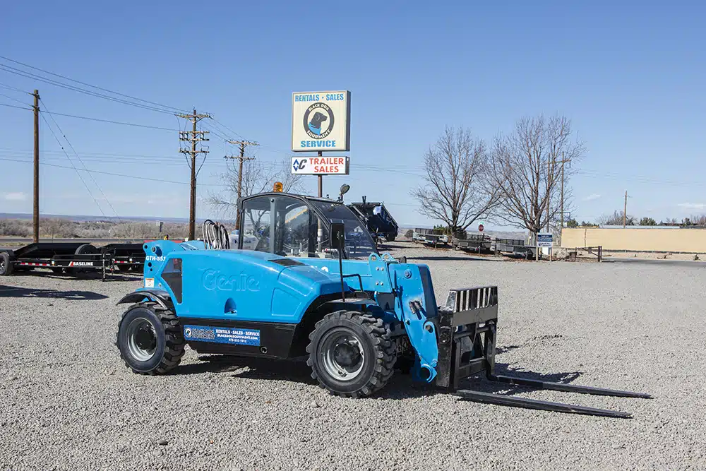 Blue Genie Telehandler For Rent in Montrose with Black Dog Equipment sign in the background